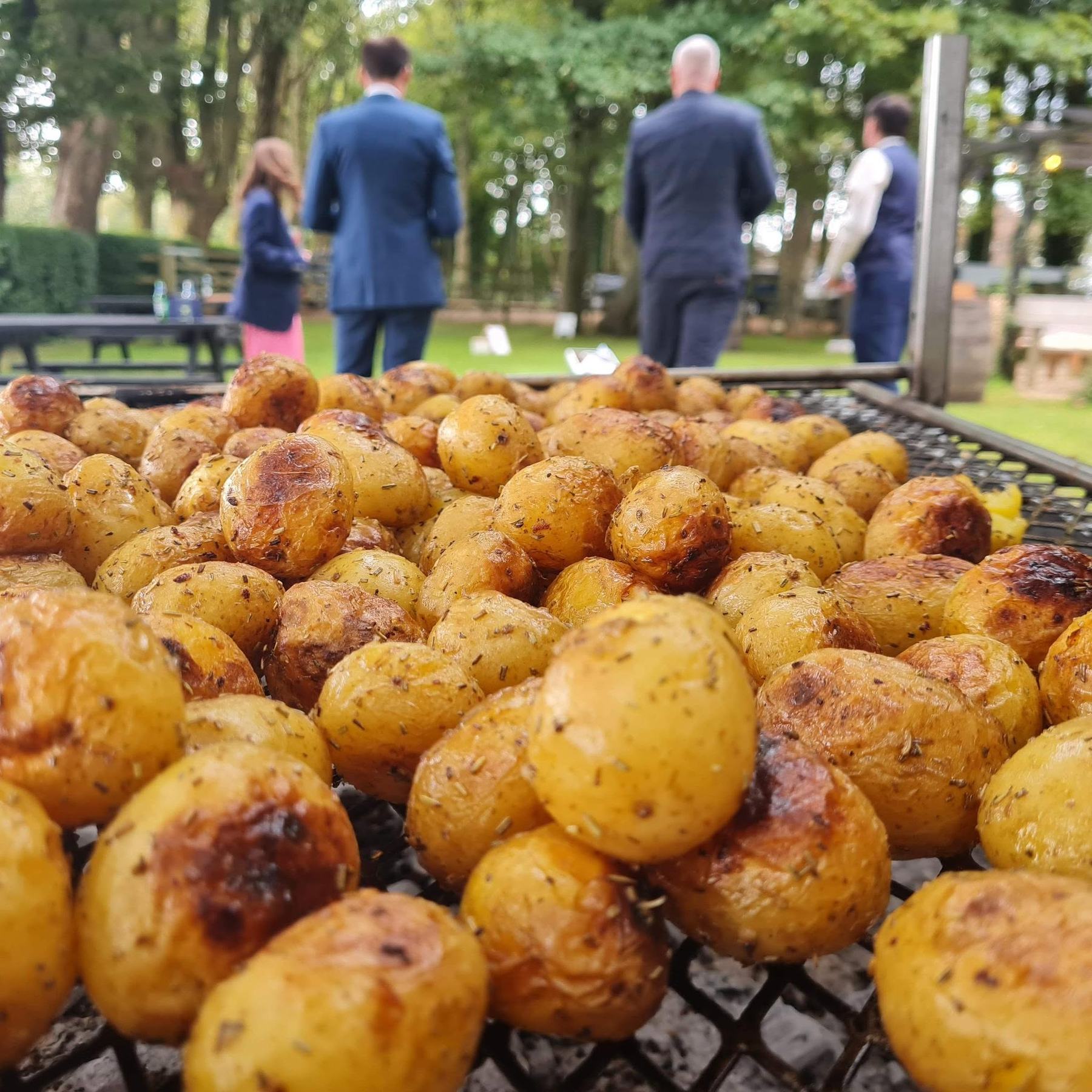 Rosemary roast potatoes charring on the grill