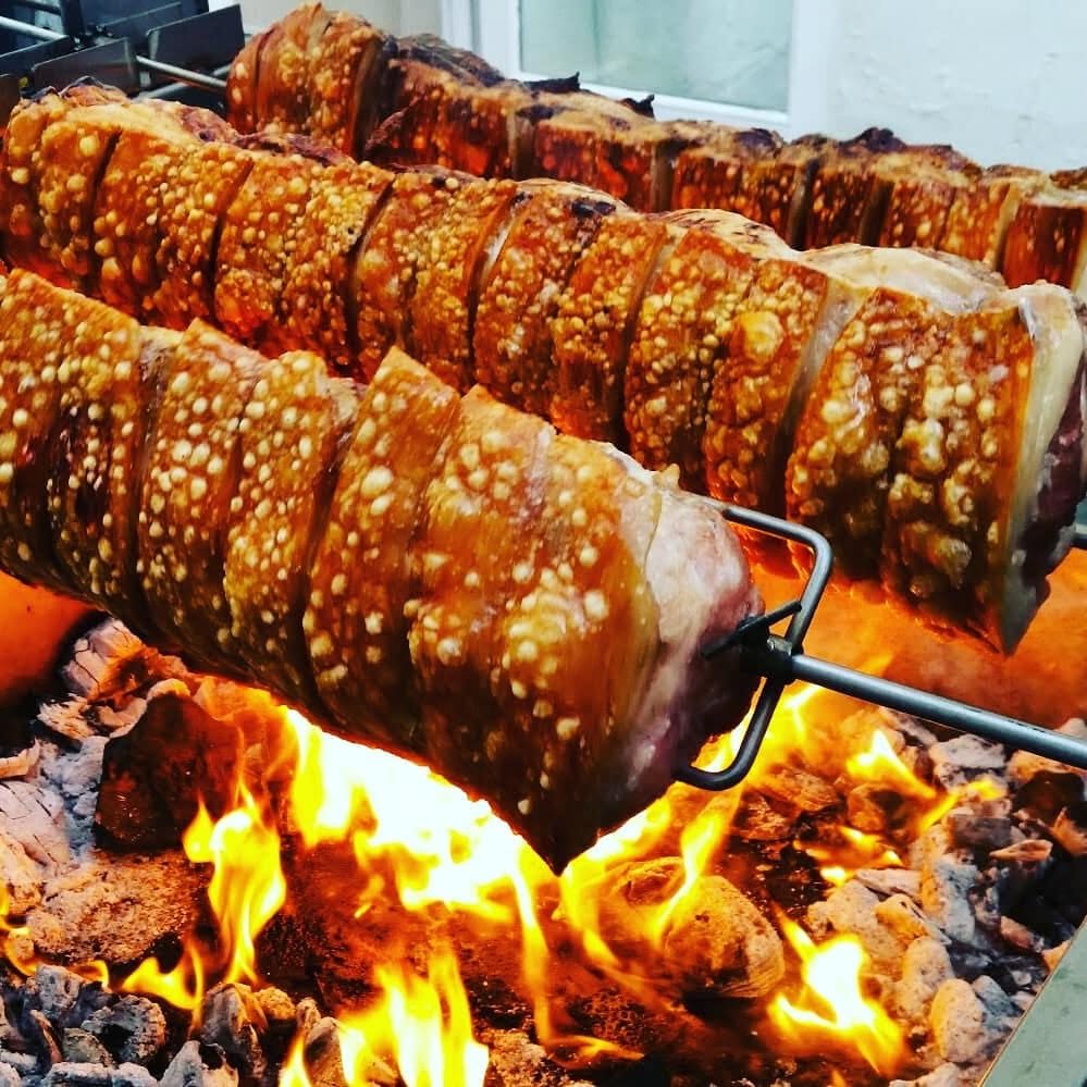 Scored pork loins turning over open flames