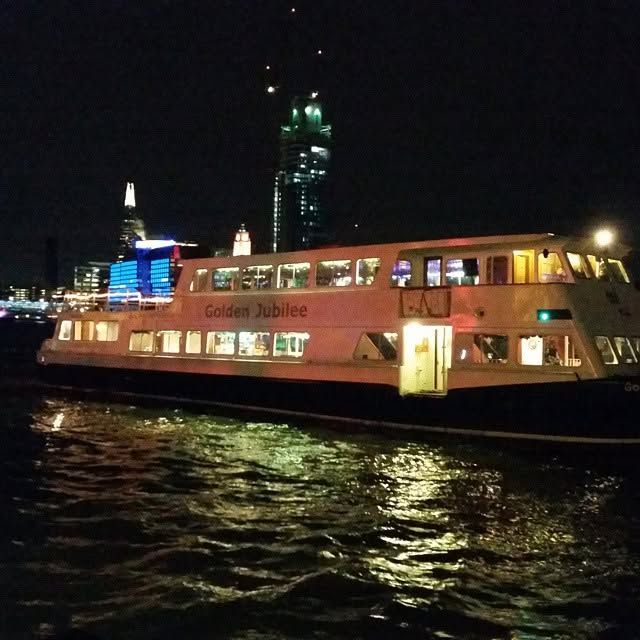 The Golden Jubilee riverboat lit up on the Thames at night