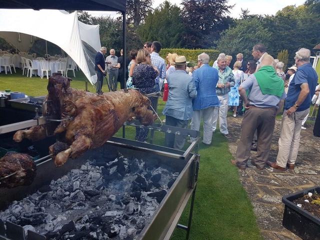 Guests gather round the hog roast