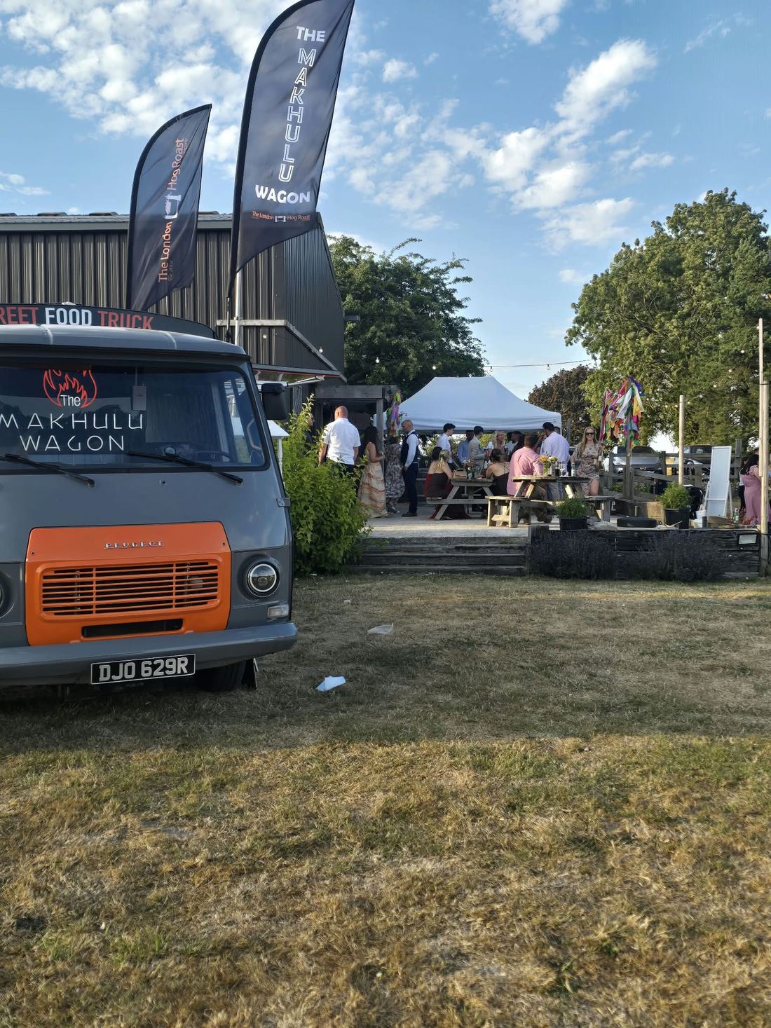 The Makhulu Wagon parked at a sunny festival with gazebos behind