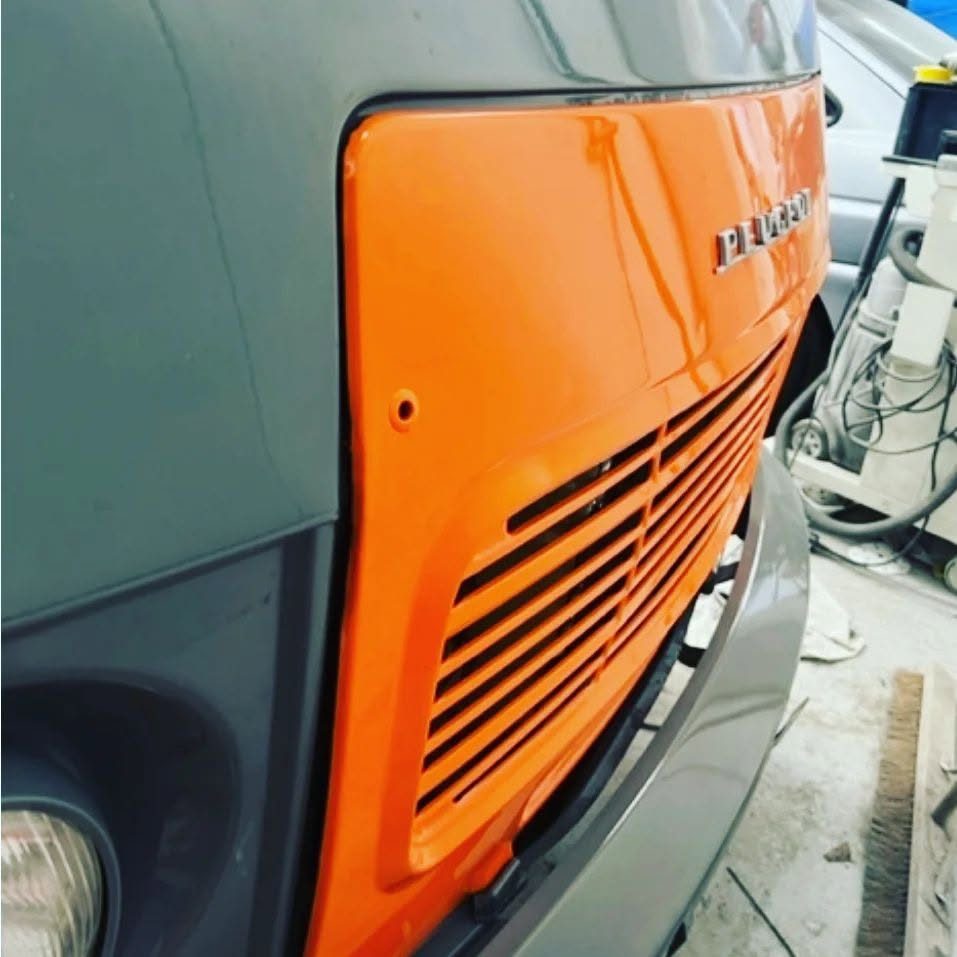 Close-up of the freshly painted orange Peugeot grille